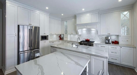 White shaker kitchen remodel in Vernon Hills with quartz waterfall island, marble subway tile backsplash, and stainless steel appliances
