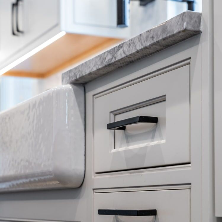 Matte black cabinet hardware on white shaker kitchen cabinets for a Lotus Home Improvement remodel