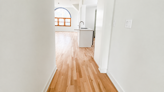 Refinished natural hardwood flooring extending through a bright Chicago home.