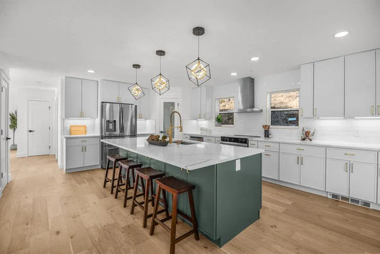 Green kitchen island with white shaker cabinets, quartz countertops, and brass hardware