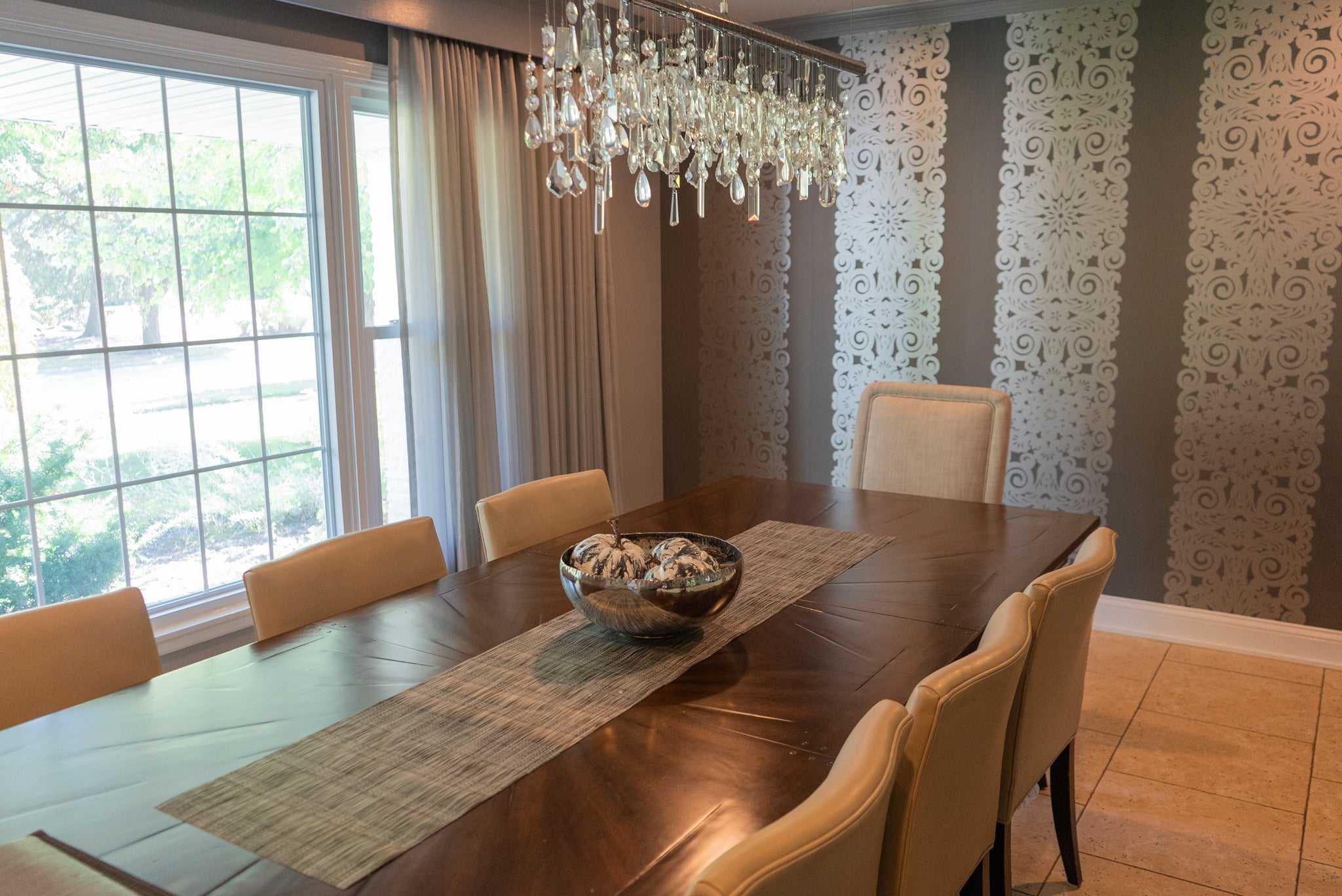 Dining room with a long wooden table, chairs, and decorative wall panels