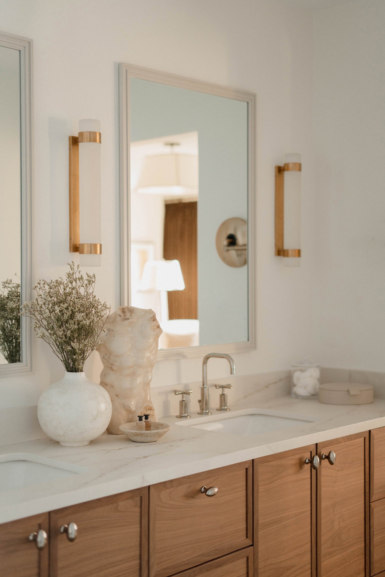 Bathroom vanity with mirror, lights, and decorative items