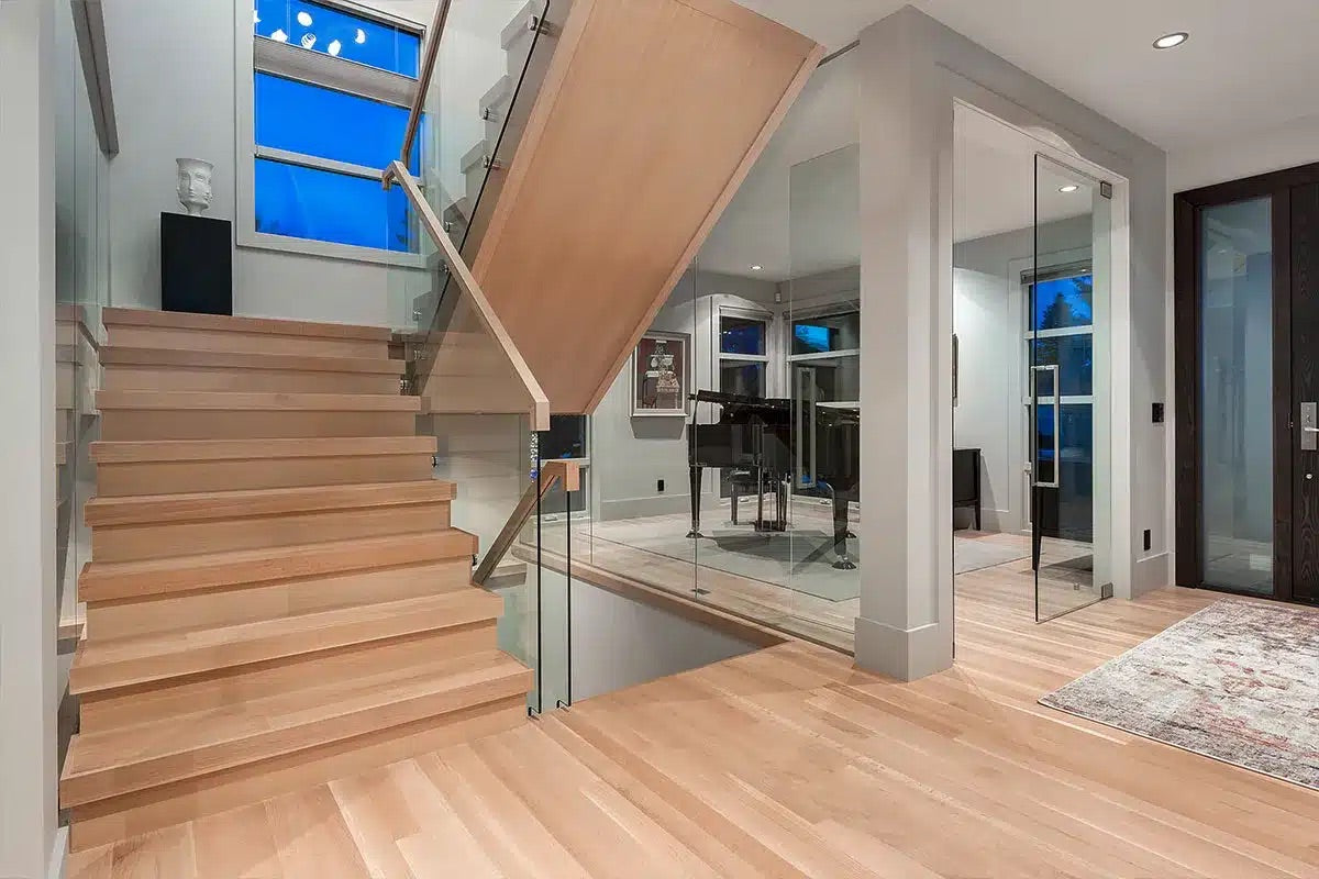 Wooden staircase in a modern home interior with glass railings