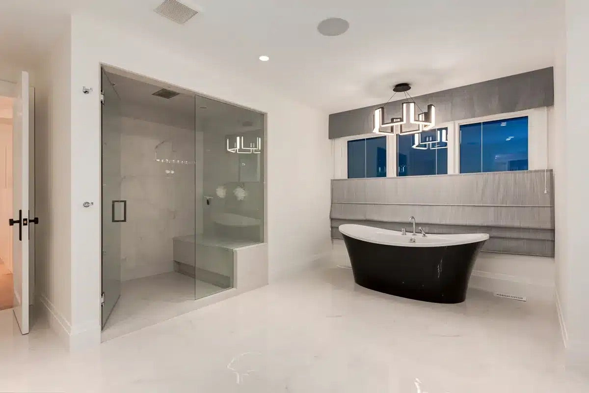 Modern bathroom with a freestanding bathtub, shower, and large mirror