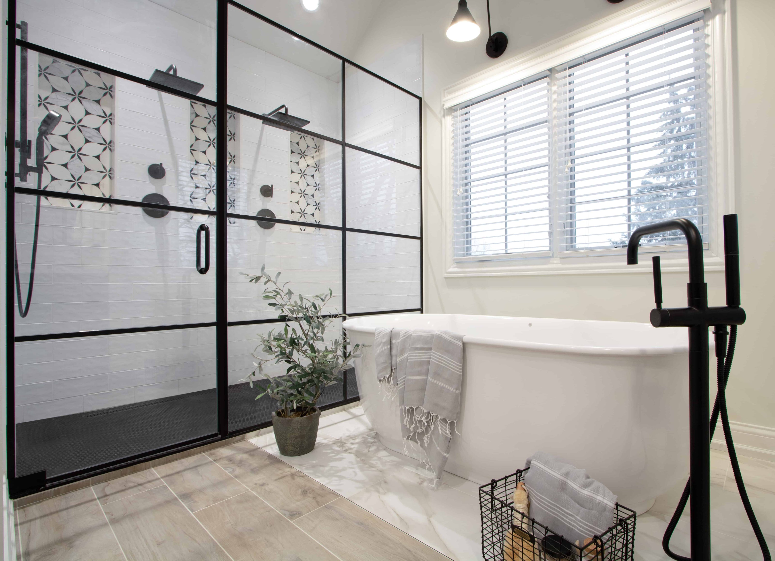 Modern bathroom with glass shower enclosure, bathtub, and window