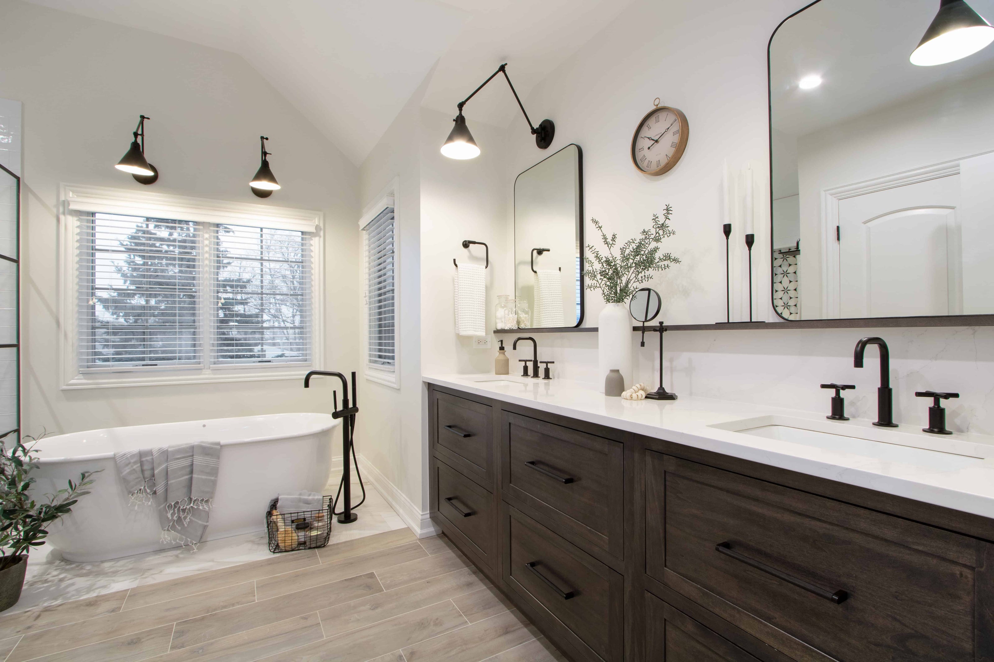 Master bathroom with freestanding tub, dark wood double vanity, and matte black fixtures