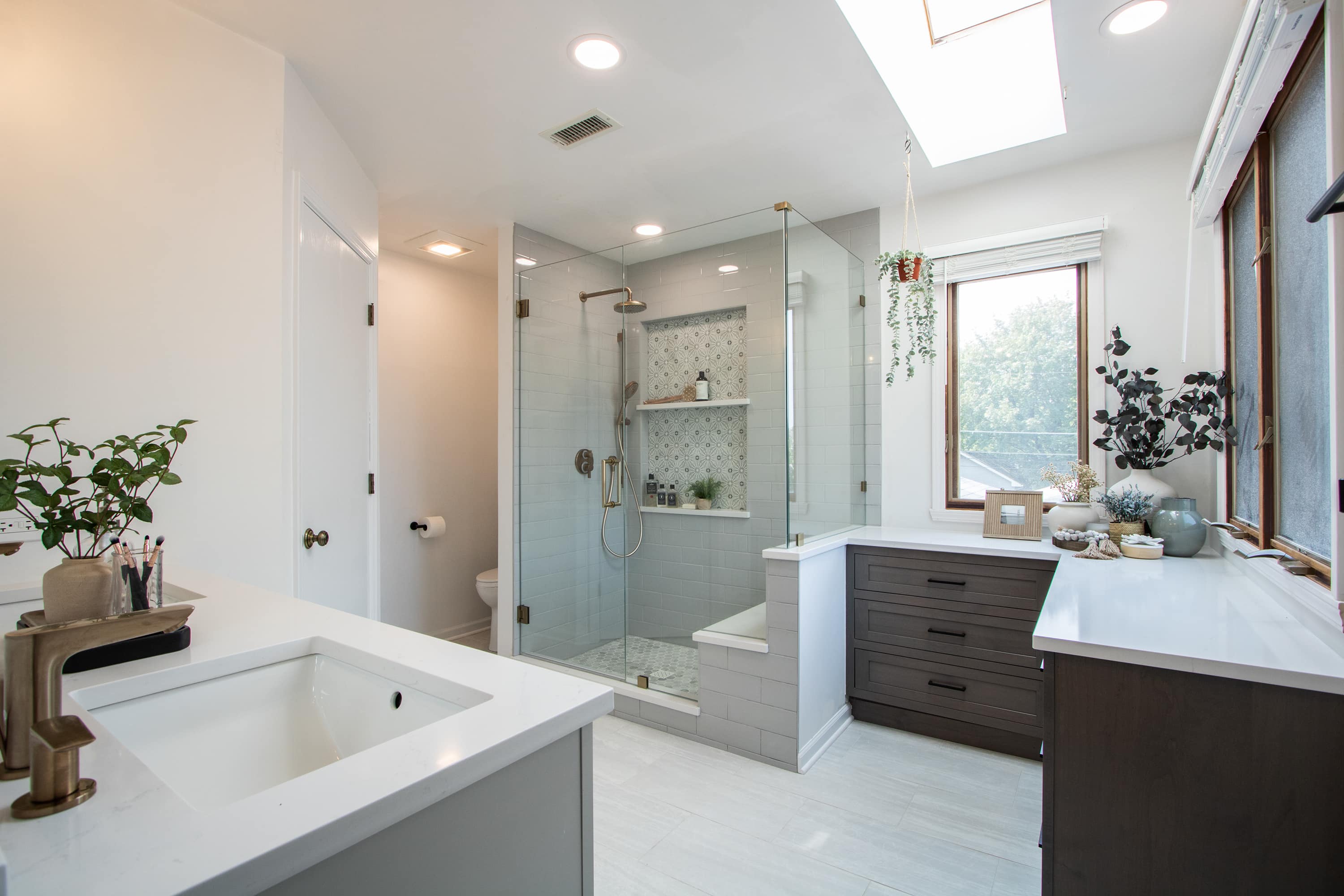 Modern bathroom with white vanity, shower, and large window