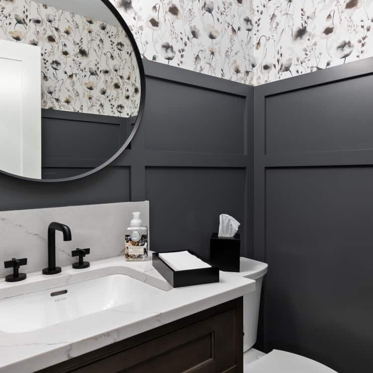 Modern bathroom with dark grey walls, white marble countertop, and black fixtures