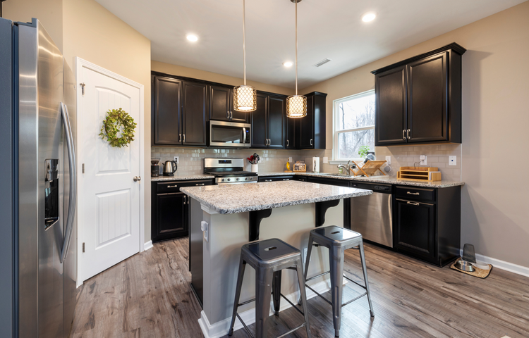 Modern kitchen with dark cabinets, stainless steel appliances, and a island