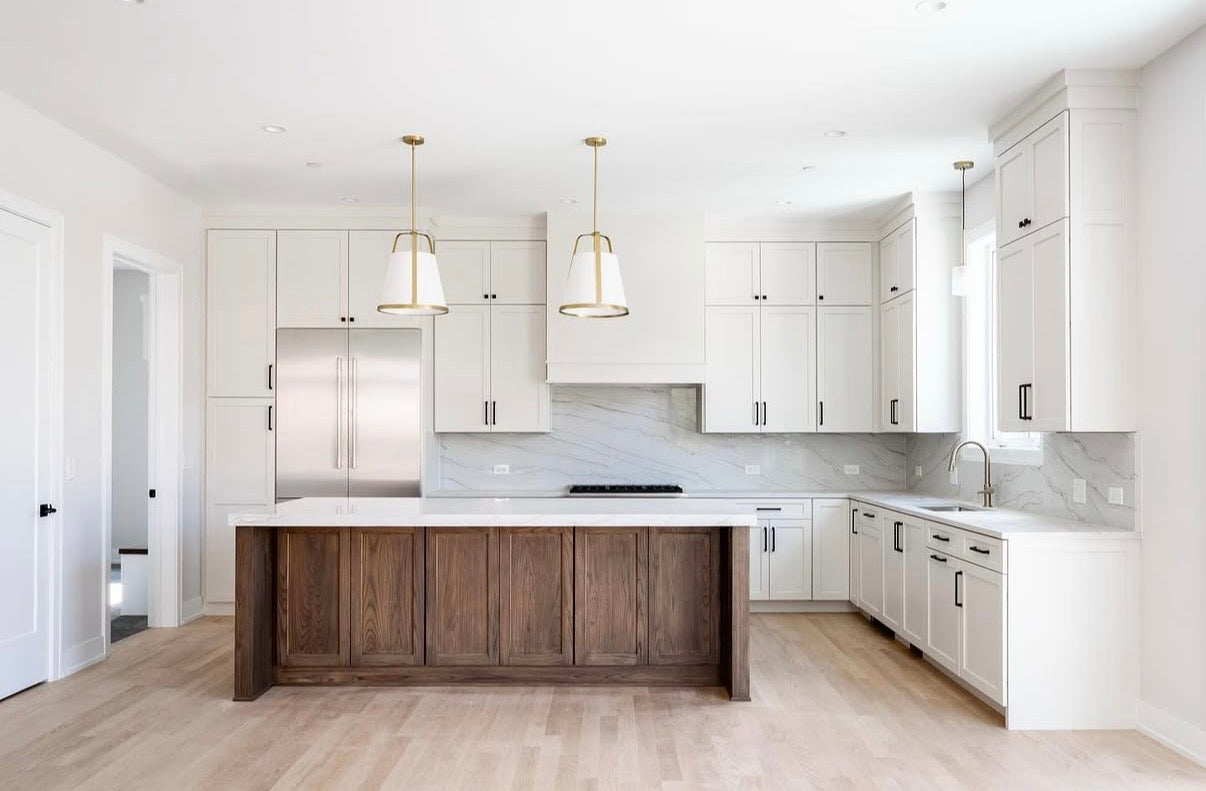 Modern kitchen with white cabinets, wooden island, and marble countertops